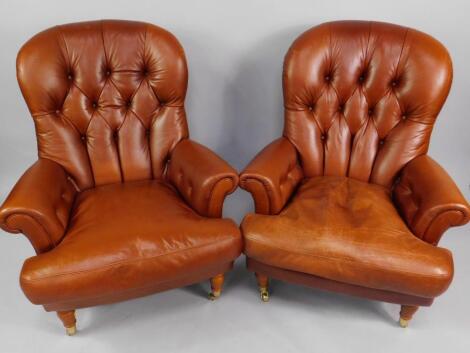 A pair of button back tan leather armchairs