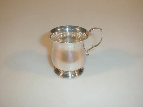 A silver baluster mug with a double scroll handle