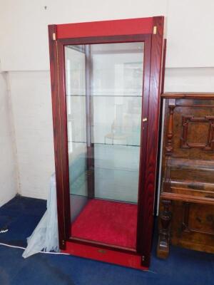 A red stained oak and laminate display cabinet