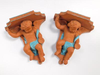 A pair of Minton late 19thC terracotta and blue glazed wall shelves