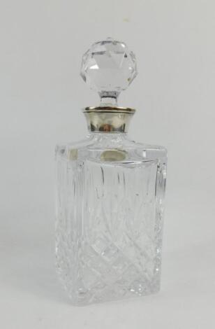 A cut glass decanter and stopper with silver mount