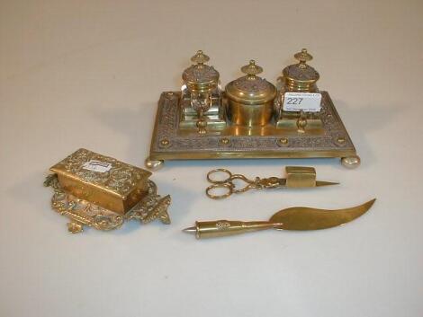 A brass rectangular desk stand with two ink receivers and ornate copper