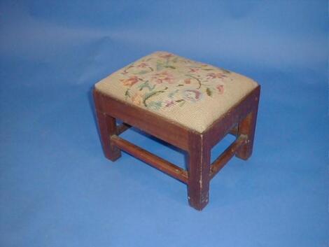 A small mahogany stool with wool work top