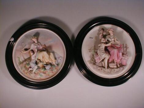 A set of four continental relief moulded bisque porcelain plaques