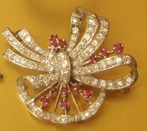 A ruby and diamond spray brooch in the form of a bow