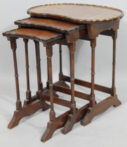 A nest of three kidney shaped mahogany tables