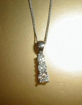 A three stone graduated diamond pendant (total approx 0.50ct) set in white