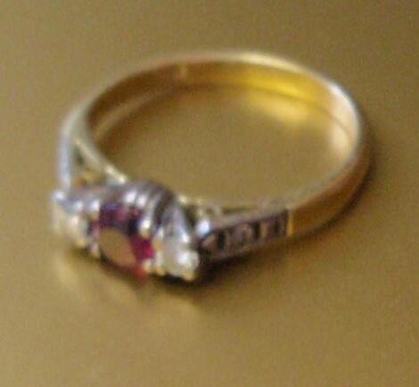 An 18ct gold ruby and diamond three stone ring