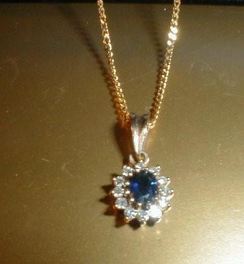 A 9ct gold sapphire and diamond pendant on a fine link chain