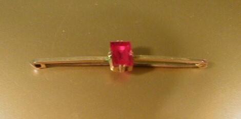 A 9ct gold bar brooch set with a single ruby