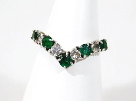 An 18ct white gold diamond and emerald ring