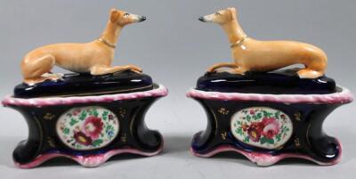 A pair of Staffordshire pottery greyhound topped inkwells