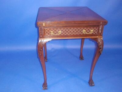 An Edwardian walnut card table with envelope folding top