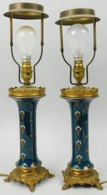 A pair of gilt metal and pottery Empire style table lamps