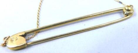 A yellow metal plain bar brooch