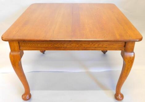 An early 20thC oak extending dining table