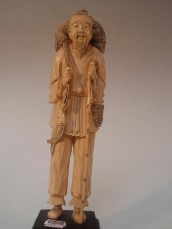 A Japanese carved ivory okimono figure of a fisherman on a hardwood stand