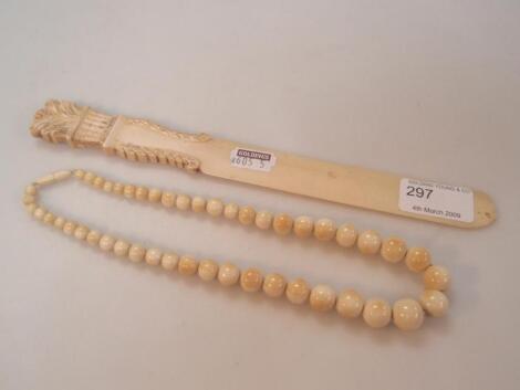 An ivory graduated bead necklace and a page turner