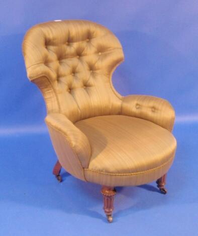 A Victorian nursing chair with shaped and buttoned upholstery and raised