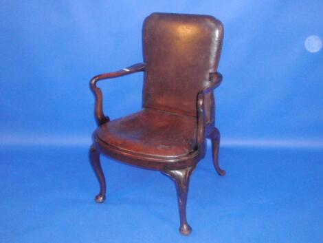 A walnut open armchair in George I style with studded leather back