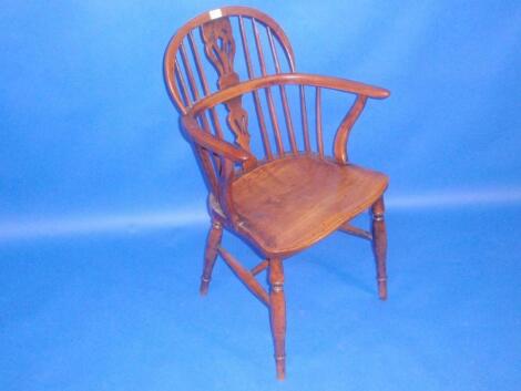 A early 19thC yew wood low back Windsor armchair with pierced vase splat