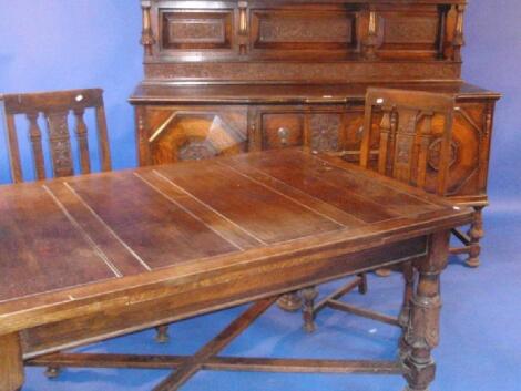 A heavy carved oak dining room suite comprising sideboard