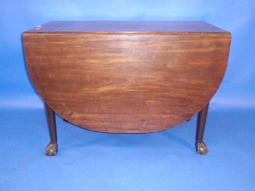 A Georgian mahogany drop leaf dining table raised on ball and claw feet