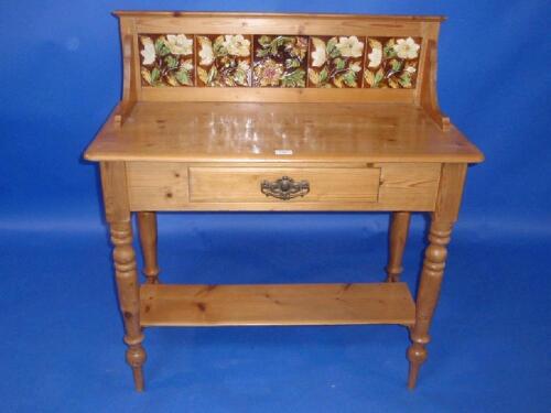 A Victorian stripped and waxed pine washstand with rustic tiled back