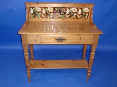 A Victorian stripped and waxed pine washstand with rustic tiled back