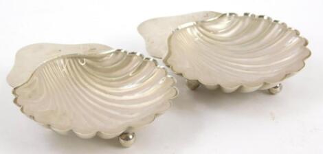 A pair of Edwardian silver shell shaped butter dishes