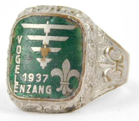 A silver plated and green enamel scouting ring