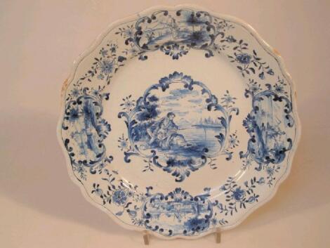 An early 20thC Dutch Delft plate painted in blue with figural vignettes and flower sprays