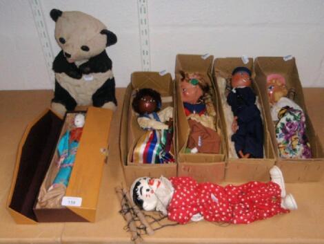 Four Pelham puppets, boxed, another, unboxed, a Japanese costume doll, a stuffed panda