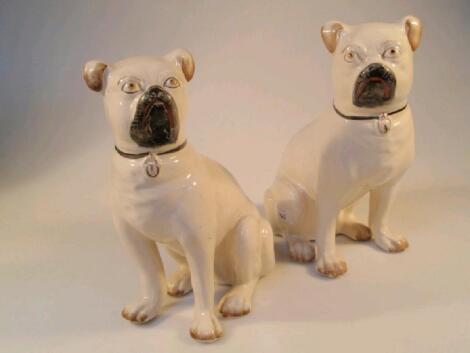 A pair of pottery seated pugs with black red muzzles