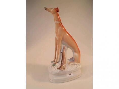 A Staffordshire figure of a seated greyhound with dead game on oval waisted