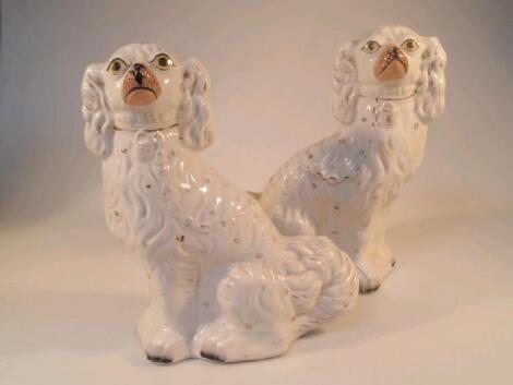 A pair of 19thC Staffordshire seated dogs with painted eyes and muzzle