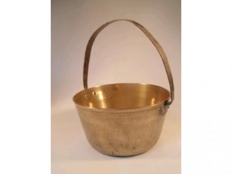 A brass jam pan with fixed overhead iron handle