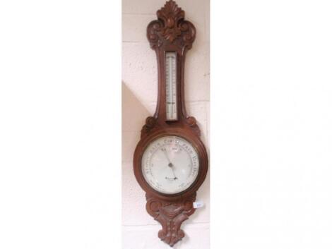 An Edwardian carved oak aneroid wheel barometer with cartouche and scroll pediment