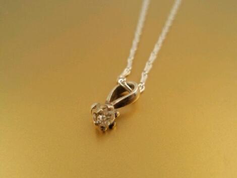 A solitaire diamond pendant of 0.07ct approx set in white gold on a 15"