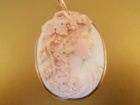 A cameo pendant of a woman's head wound with vines and grapes in high relief