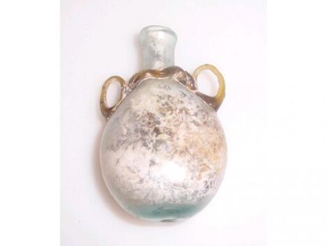 A small post-Roman pale bluish-green glass flask with a flattened globular body