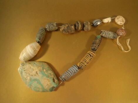 A collection of fifteen assorted ancient beads mostly in polychrome glass