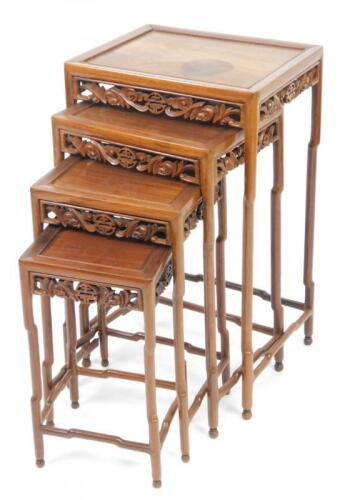 A nest of four Chinese carved wooden tables