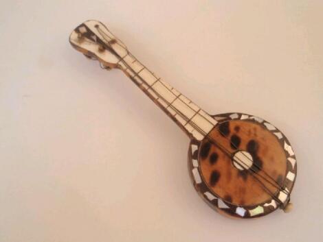 A miniature tortoiseshell covered model of a banjo