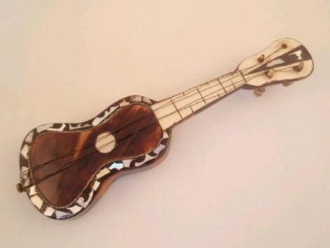 A miniature tortoiseshell covered model of a guitar