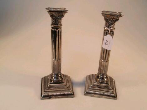 A pair of Edwardian silver table candlesticks of classical Corinthian column design