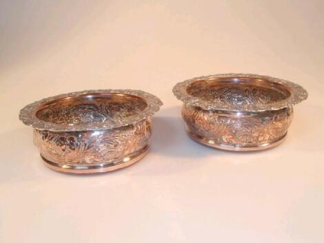 A pair of silver plated wine coasters with everted rims