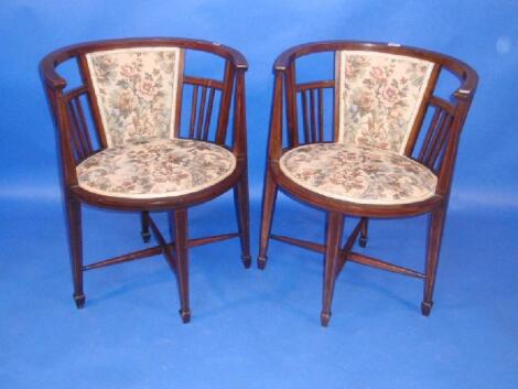 A pair of Edwardian string inlaid mahogany boudoir chairs with oval seats and padded backs