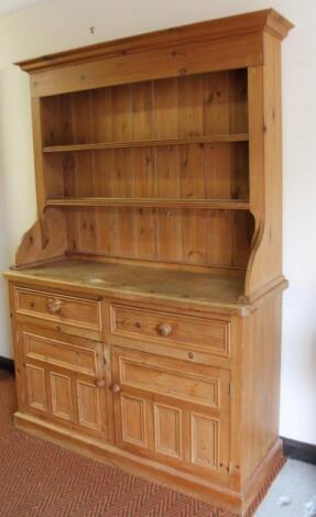 A stripped and lightly polished pine kitchen dresser