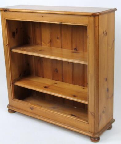 A stripped and lightly polished freestanding pine bookcase